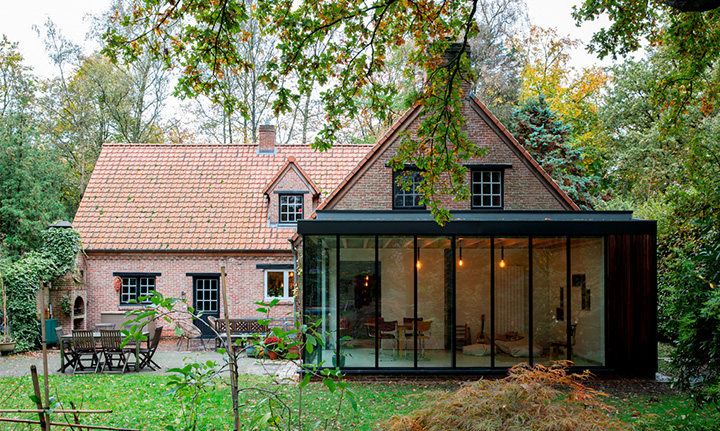 Landelijke woning met nieuwe aanbouw, exterieur in avondlicht